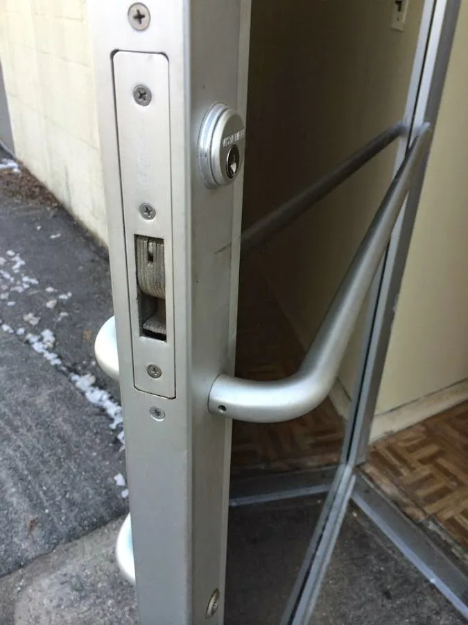 Technician working on a lock mechanism in a commercial setting